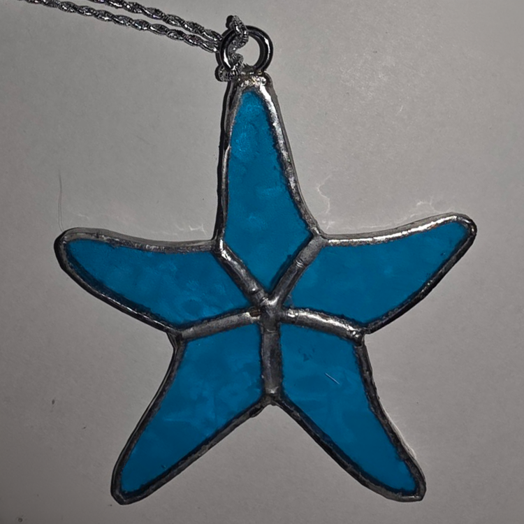 Stained glass starfish pendant in bright ocean blue with silver solder detailing.