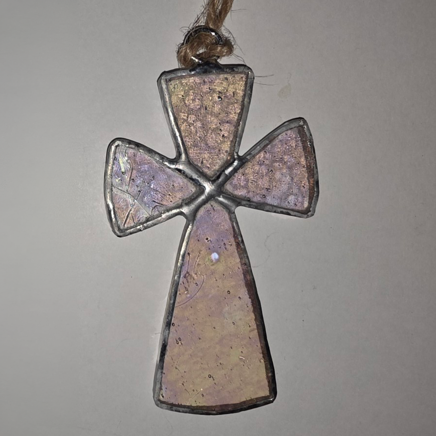 Iridescent blush stained glass cross ornament with silver solder and twine hanger.