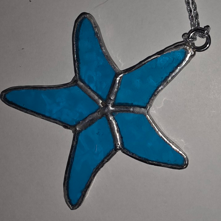 Stained glass starfish pendant in bright ocean blue with silver solder detailing.